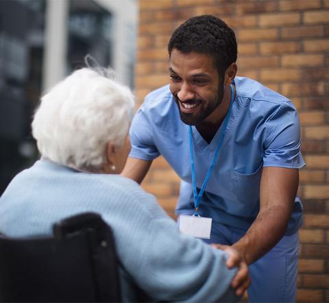 carer smiling at older lady outside